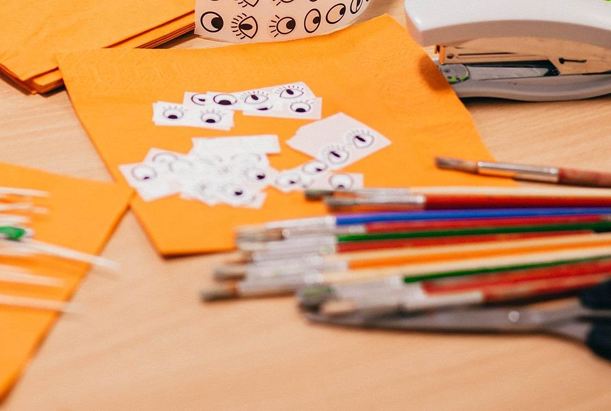 Materiały plastyczne przygotowane do zajęć w przedszkolu Sezamkowe, kartki, naklejki i przybory do prac manualnych.