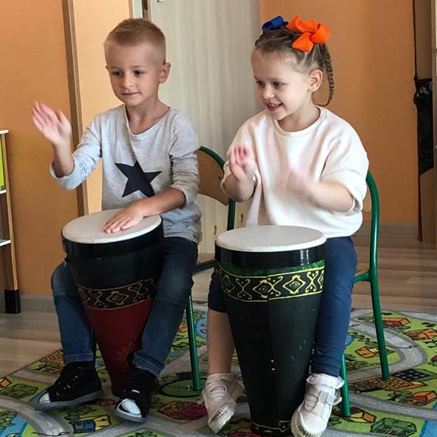 Zajęcia muzyczne w przedszkolu Sezamkowe, dzieci grają na instrumentach perkusyjnych i ćwiczą rytmikę.